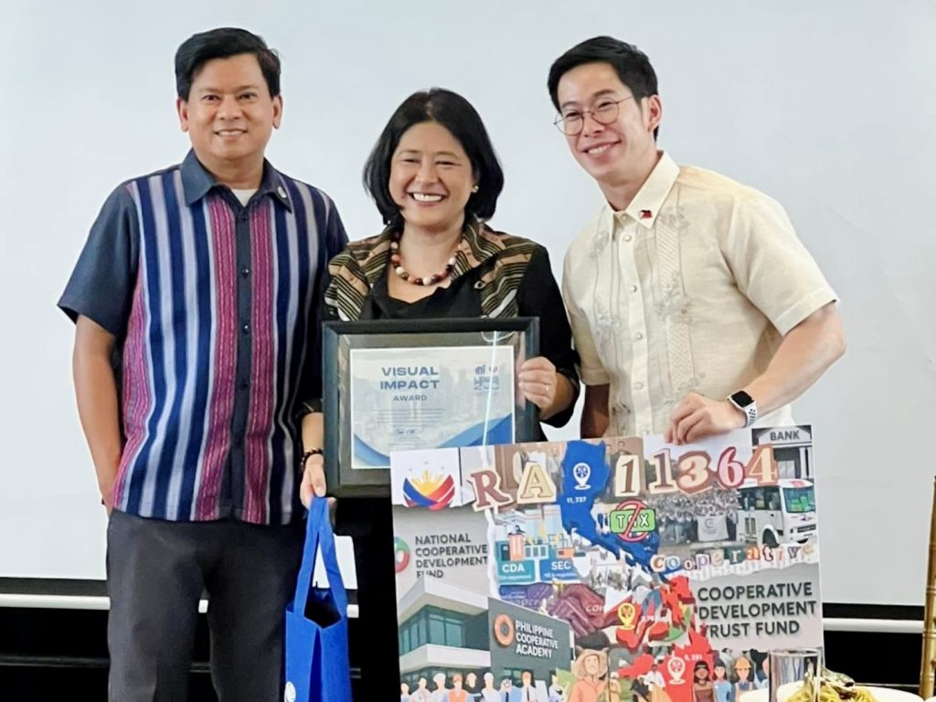 Deputy Administrator for Legal Affairs Service ATTY. LEAH B. BANAGUI-HAN receives the Visual Impact Award from the Department Legislative Liaison Officer ASEC. MICHEL KRISTIAN R. ABLAN and Chief of Staff of the DTI Secretary ASEC. ENGLEBERT JOSEF GO CHUA.
